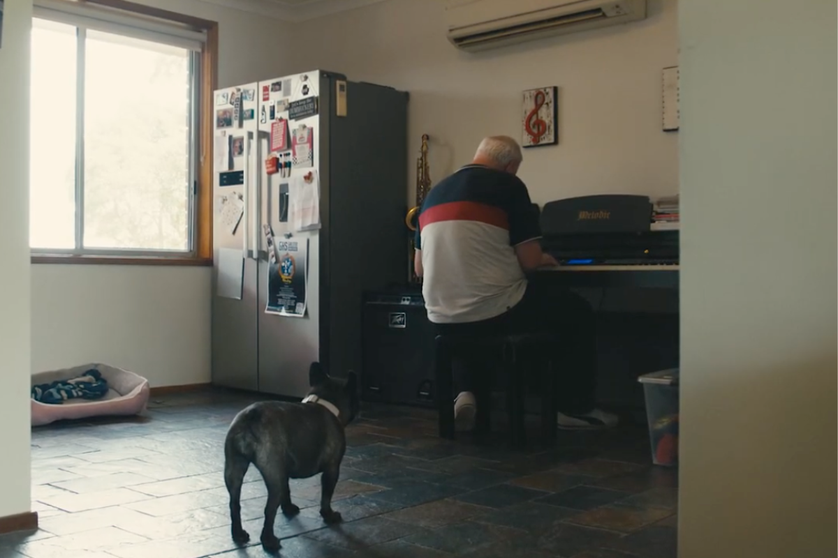 Ali playing his piano with his dog in the foreground