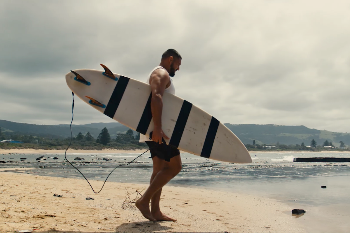 Nathan walking in to the surf with his surf board