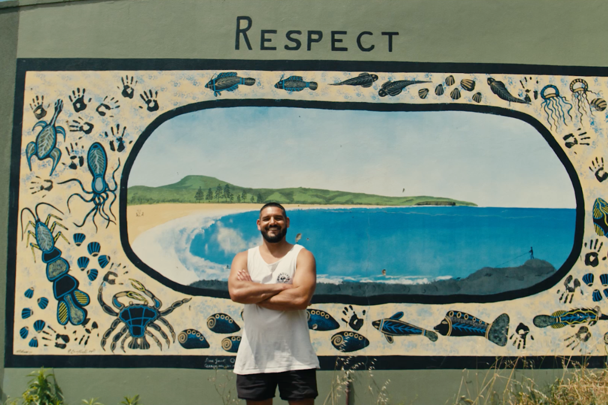 Nathan standing in front of a beach mural