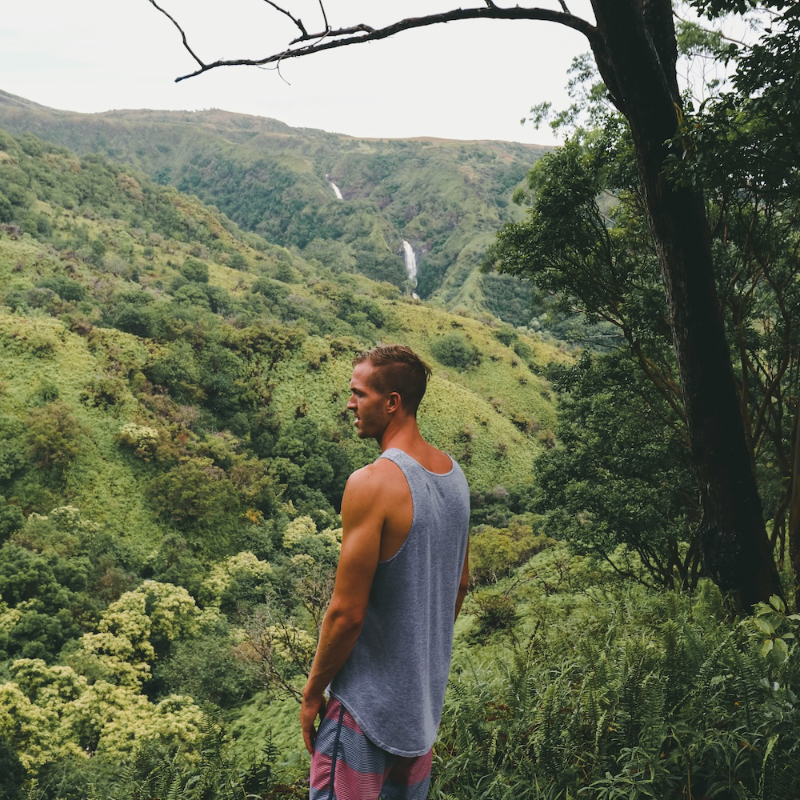 Man wearing a singlet and looking out over a forest
