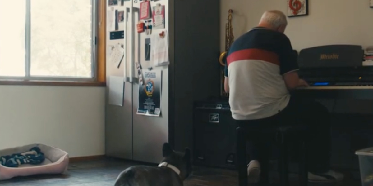 Ali playing his piano with his dog in the foreground