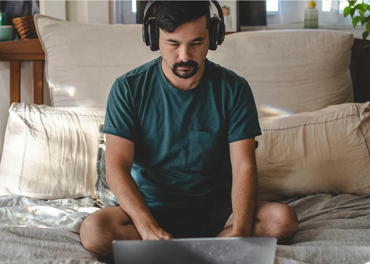 Man using a laptop while wearing headphones